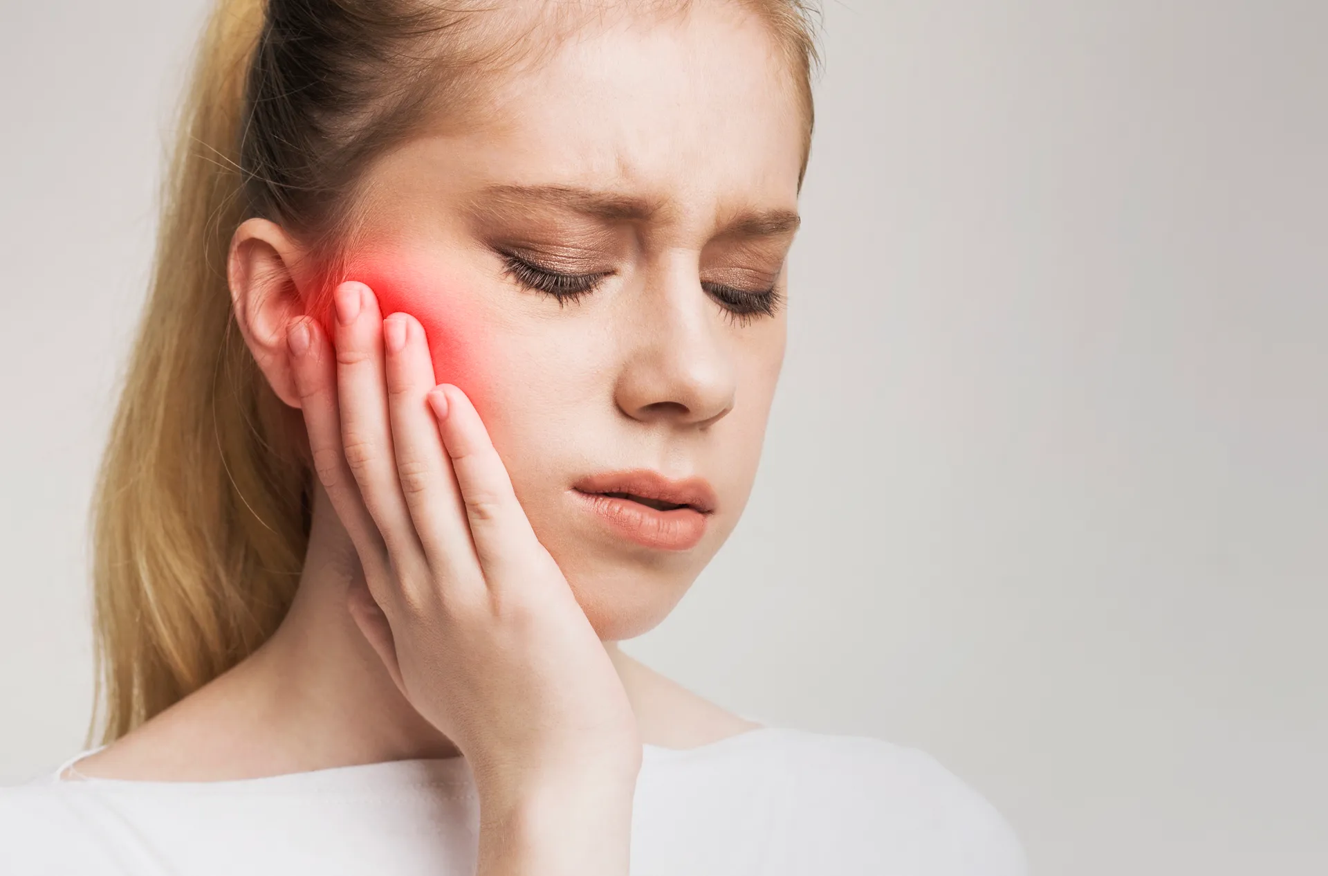 Patient experiencing jaw pain and TMJ discomfort — PBM and laser pain management at Dentistry On The Path, Toronto